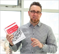 Chief Methodologist Luk Arbuckle Holding Book